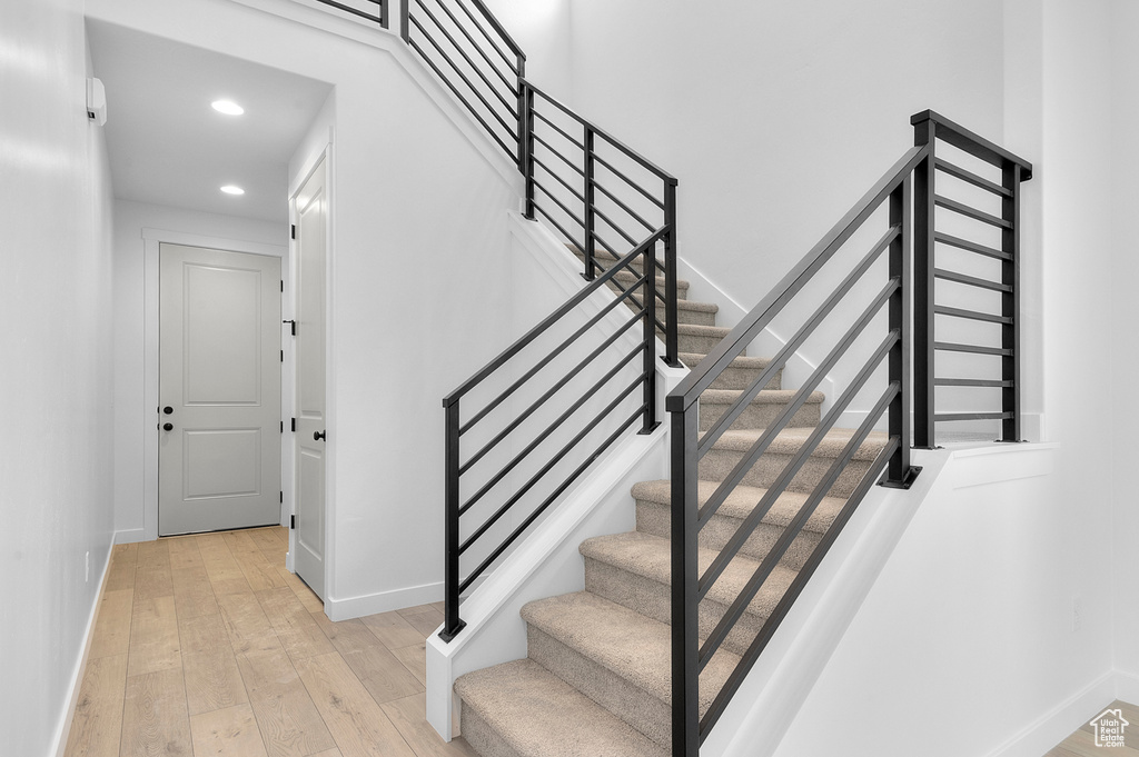 Staircase with baseboards, recessed lighting, and wood-type flooring