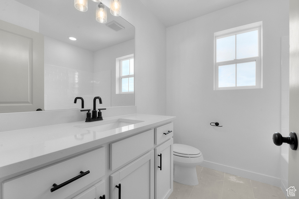 Full bathroom with vanity, toilet, baseboards, tile patterned flooring, and a shower