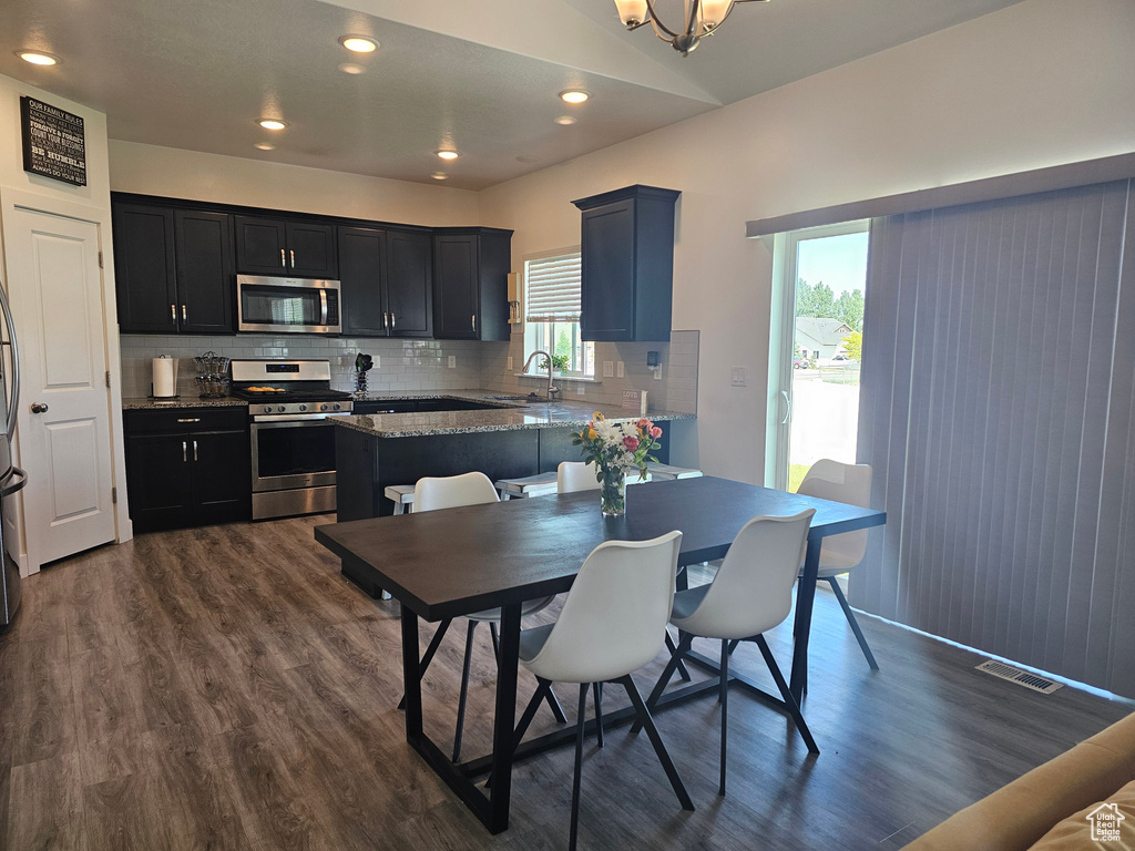 Dining area featuring dark wood finished floors, recessed lighting, and baseboards