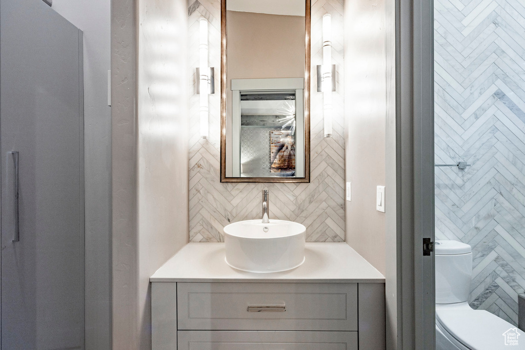 Bathroom with backsplash, vanity, and toilet
