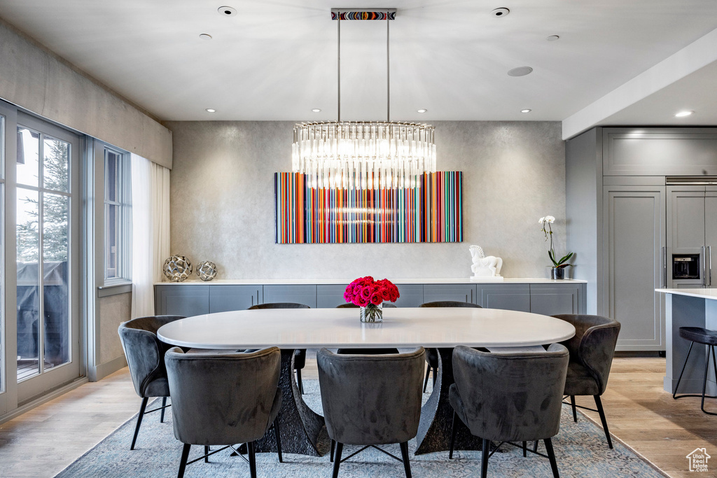 Dining room with light wood-style flooring and a chandelier