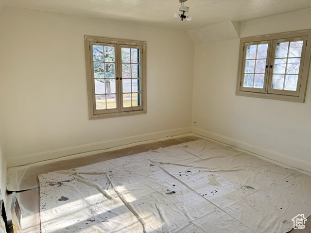 Empty room with french doors and vaulted ceiling