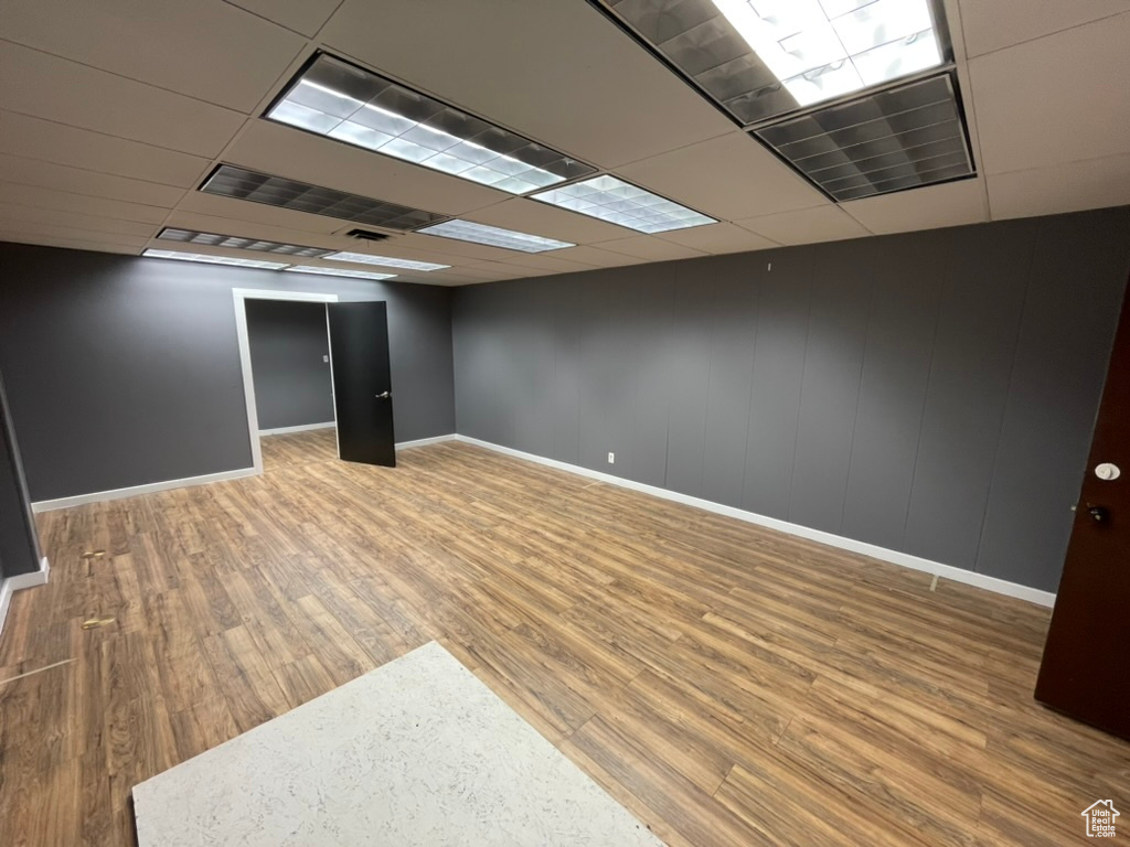 Basement with hardwood / wood-style floors and a paneled ceiling