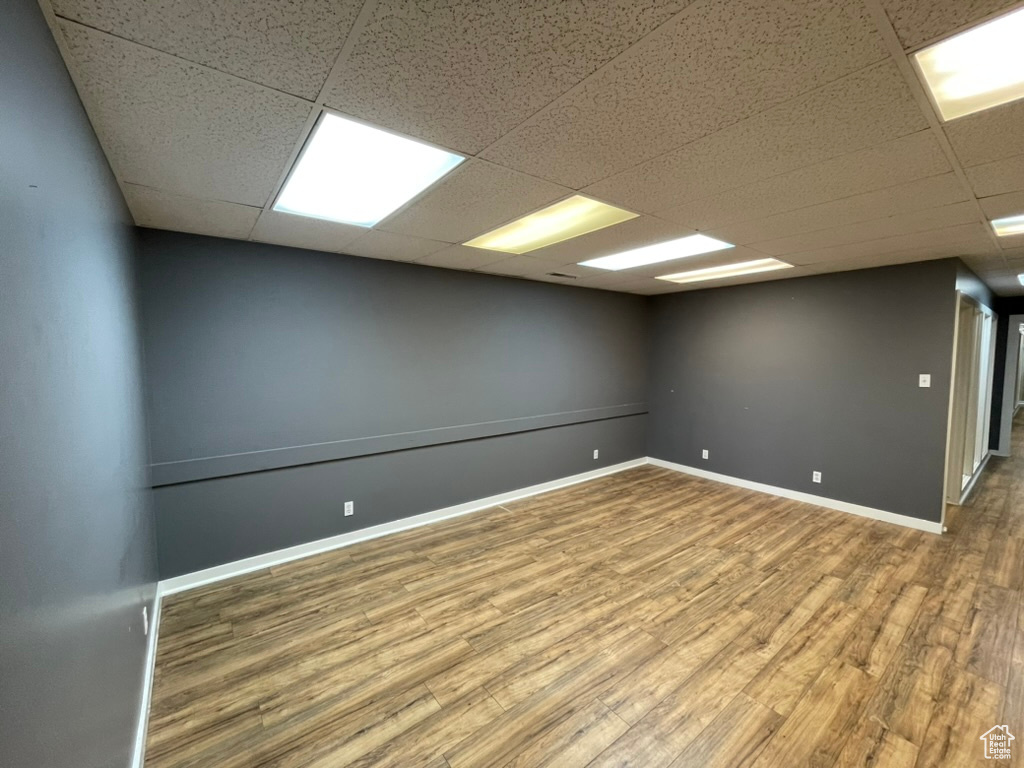 Unfurnished room with hardwood / wood-style flooring and a drop ceiling