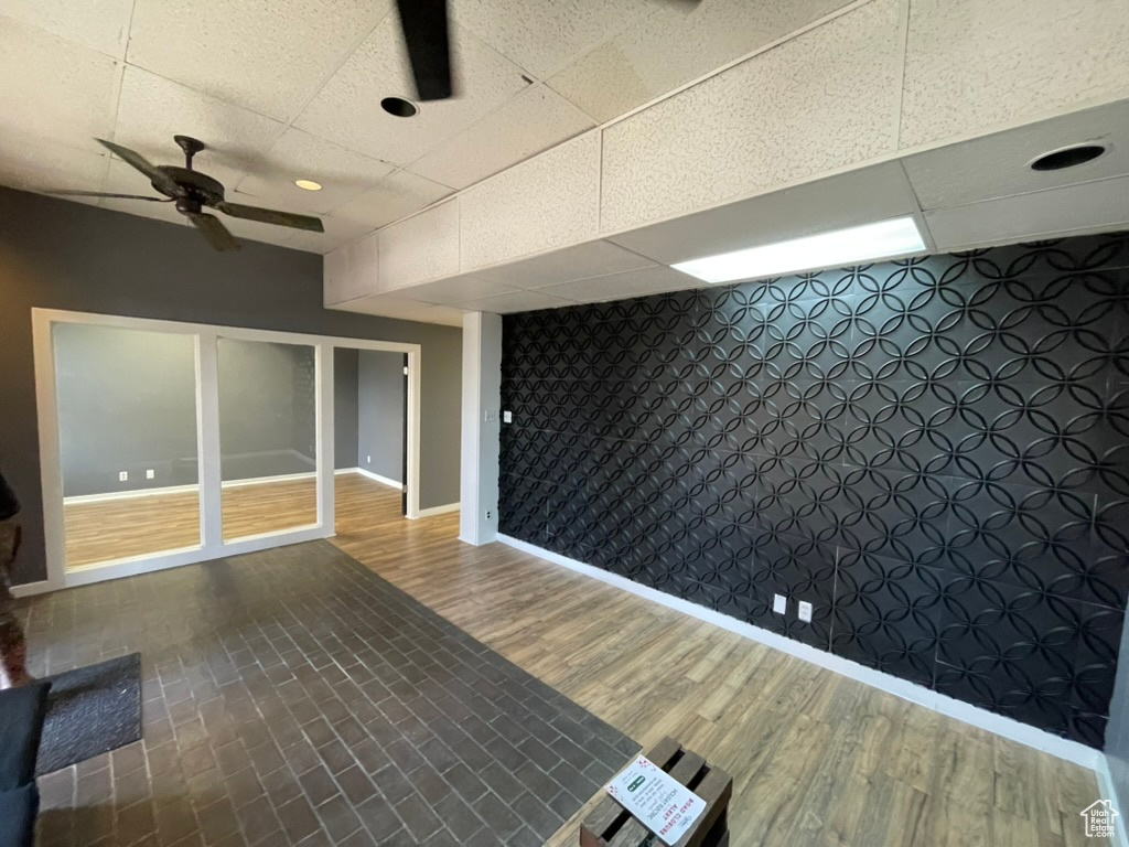 Interior space featuring wood-type flooring, a paneled ceiling, and ceiling fan