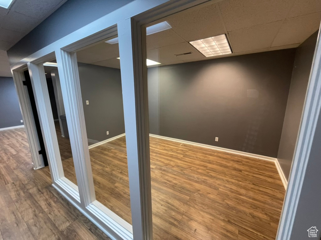 Empty room with a paneled ceiling and wood-type flooring