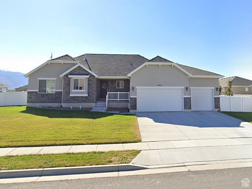 View of front facade featuring driveway, an attached garage, stucco siding, a mountain view, and a residential view