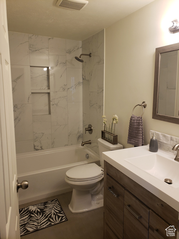 Full bathroom featuring tiled shower / bath combo, toilet, and vanity