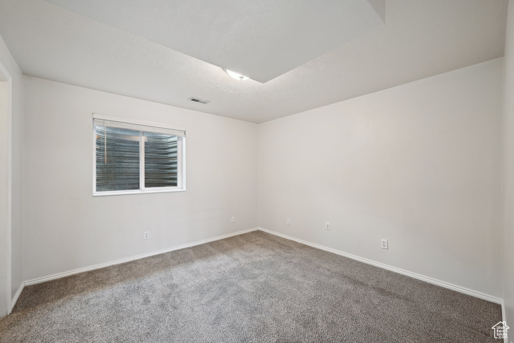 Unfurnished room featuring baseboards, visible vents, and carpet flooring