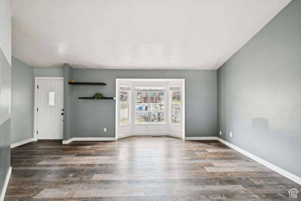 Foyer entrance with baseboards and dark wood-type flooring