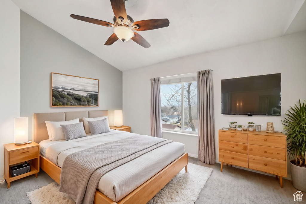 Bedroom featuring vaulted ceiling, a ceiling fan, and light colored carpet