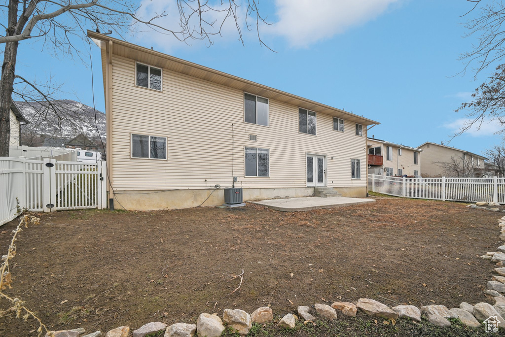 Rear view of property with french doors, central air condition unit, a gate, a patio area, and a fenced backyard