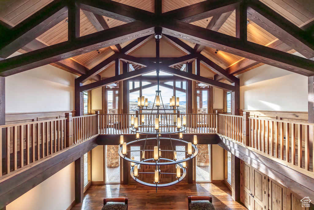 Living area with a chandelier, hardwood / wood-style flooring, and an upstairs landing