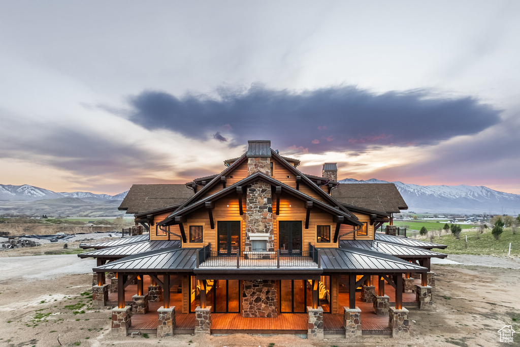 Back of house with a standing seam roof, covered porch, a mountain view, and a metal roof