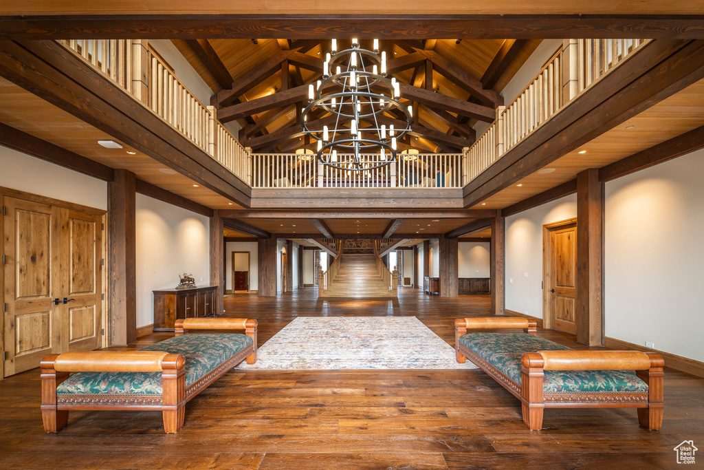 Foyer entrance featuring hardwood / wood-style floors, a chandelier, high vaulted ceiling, and beam ceiling