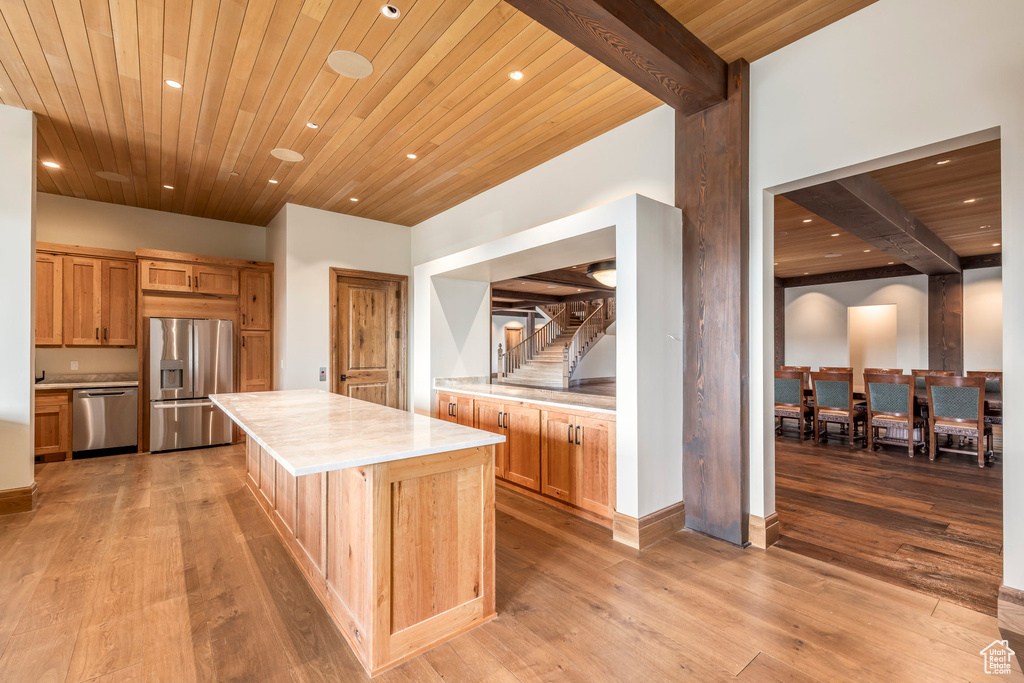 Kitchen featuring appliances with stainless steel finishes, recessed lighting, light countertops, a wood ceiling with exposed beams, and light wood-style flooring