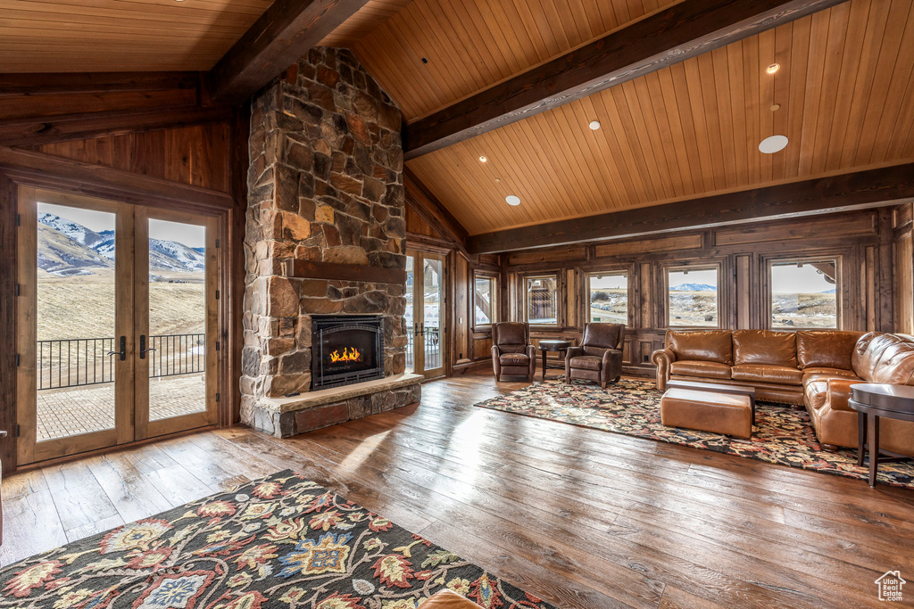 Living area featuring hardwood / wood-style floors, wood ceiling, french doors, a mountain view, and wood walls