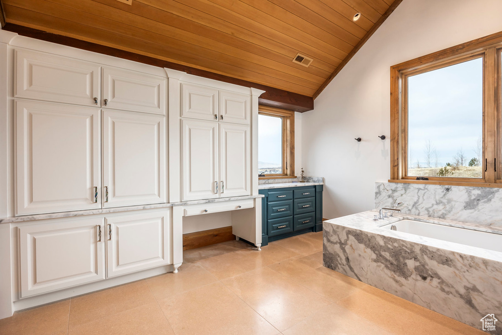 Bathroom featuring plenty of natural light, wooden ceiling, a bath, vaulted ceiling, and vanity
