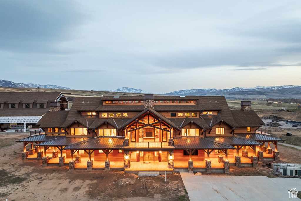 Rear view of property featuring a mountain view, a metal roof, a chimney, and a standing seam roof