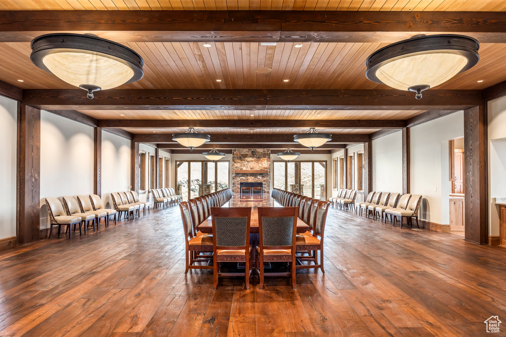 Dining room with a wood ceiling with exposed beams and hardwood / wood-style flooring