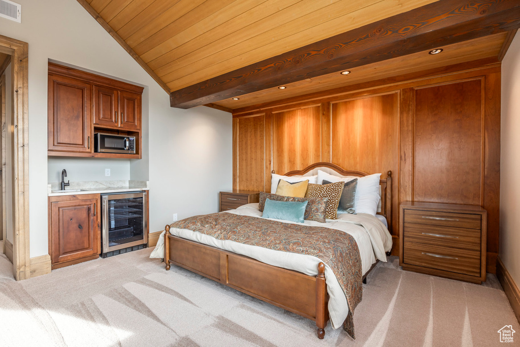 Bedroom featuring wine cooler, light colored carpet, bar with sink, vaulted ceiling, and wooden ceiling