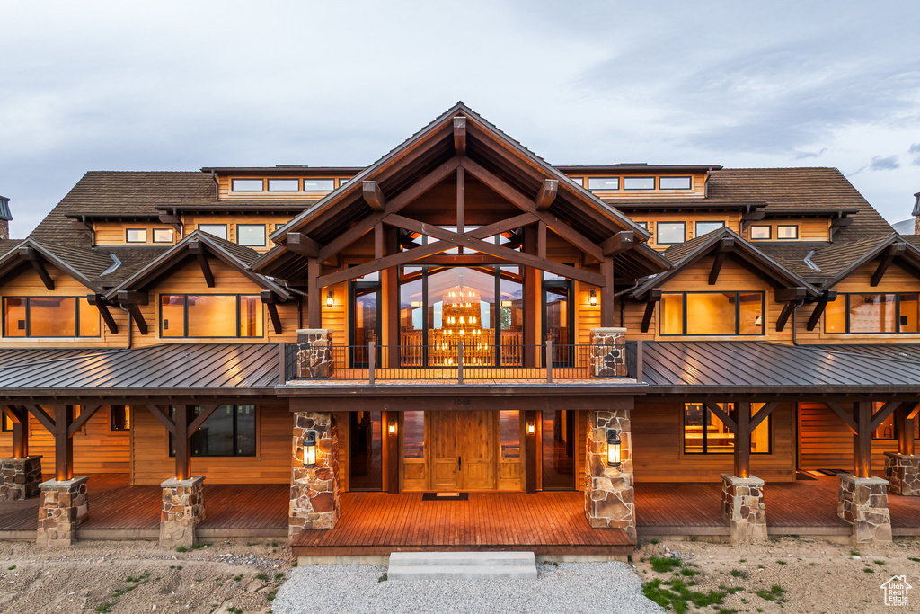 Back of house featuring a balcony and a metal roof