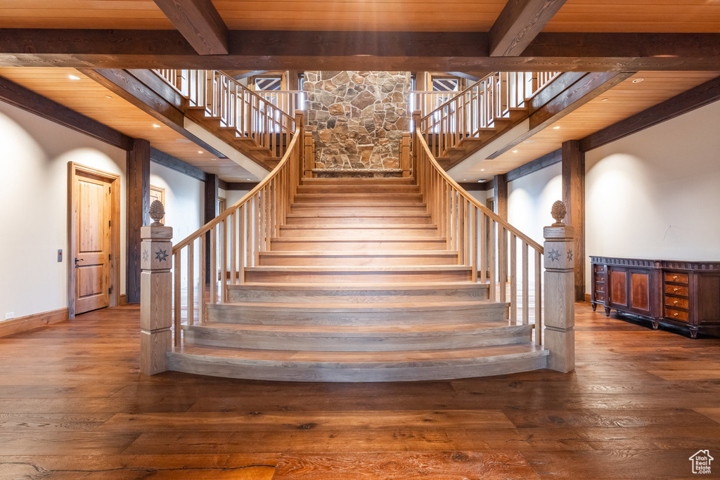Stairs with wood-type flooring, a wood ceiling with exposed beams, and recessed lighting