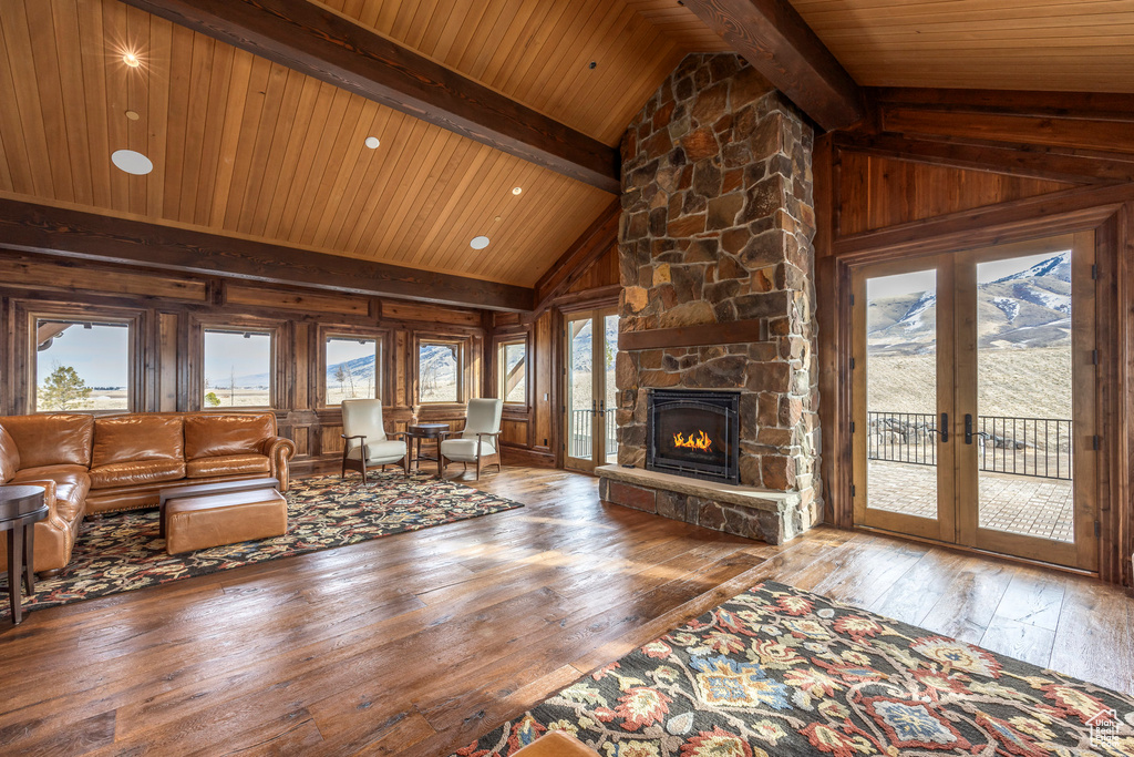 Living area with wood-type flooring, wooden ceiling, wood walls, a fireplace, and french doors