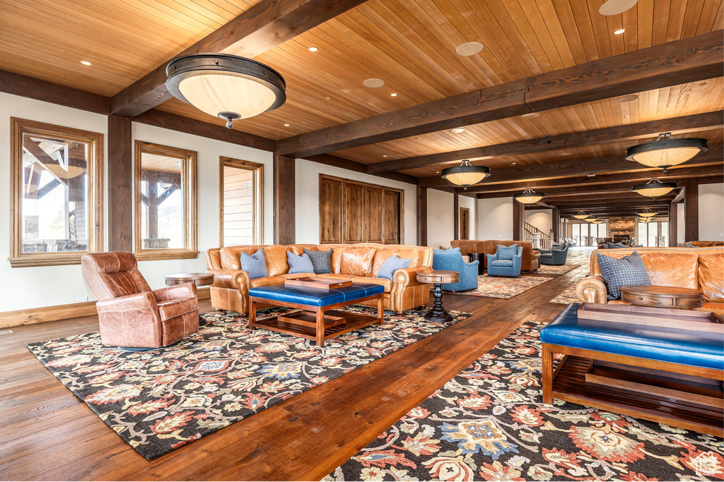 Living area featuring wood-type flooring, a wooden ceiling with exposed beams, and recessed lighting