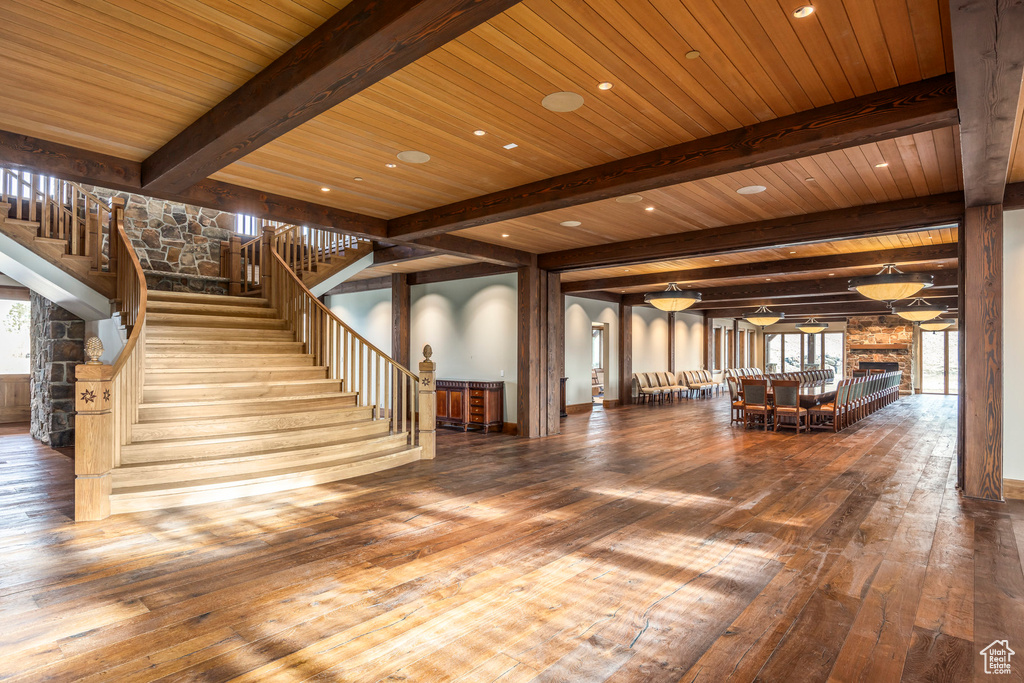Stairway with wood-type flooring, a wooden ceiling with exposed beams, and recessed lighting