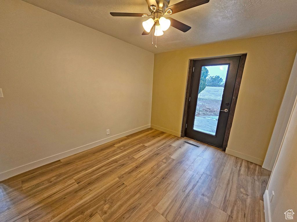 Entryway featuring ceiling fan, a textured ceiling, and light wood-type flooring