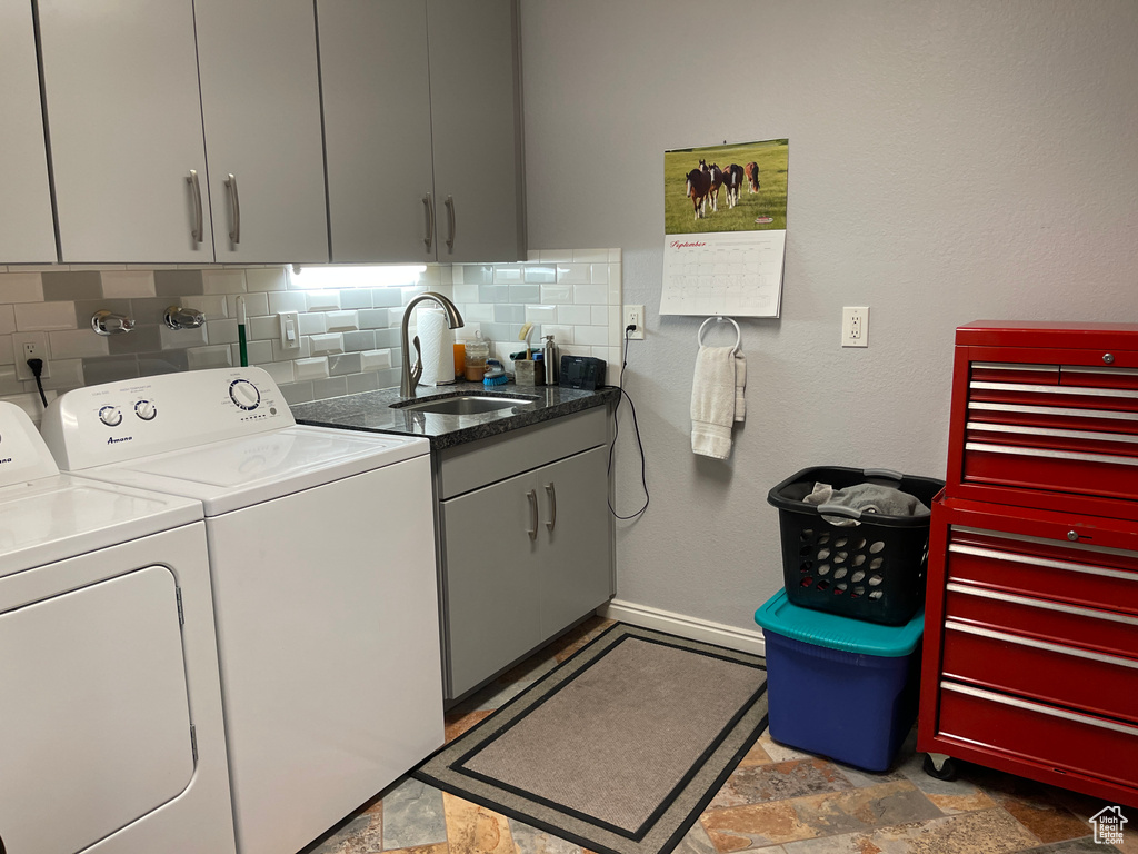 Laundry room featuring cabinets, separate washer and dryer, and sink