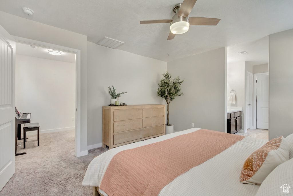 Bedroom featuring ceiling fan, light colored carpet, and connected bathroom