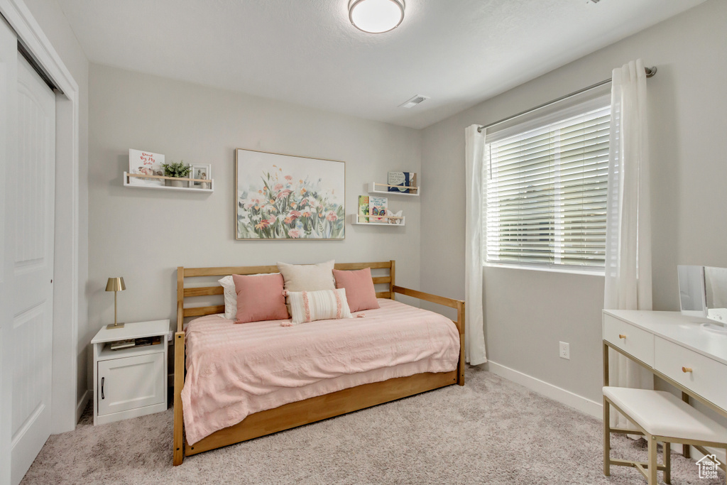 Bedroom with a closet and light colored carpet