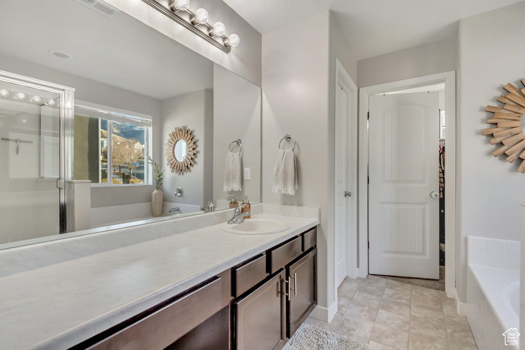 Bathroom featuring vanity, tile patterned floors, and a bathtub