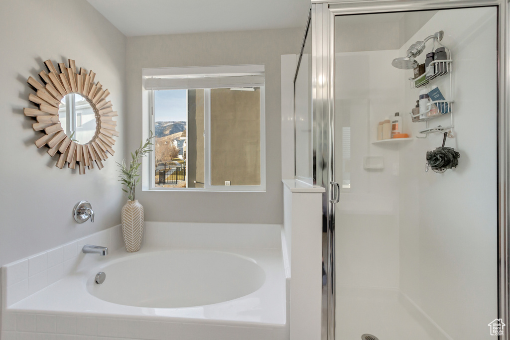 Bathroom featuring shower with separate bathtub