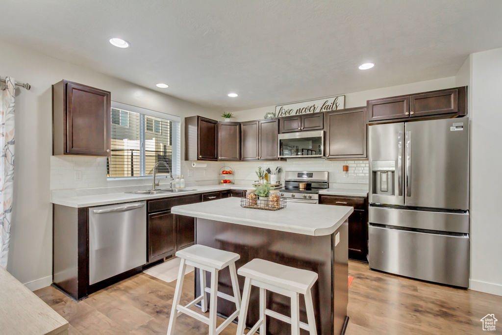 Kitchen featuring a center island, stainless steel appliances, light hardwood / wood-style floors, and sink