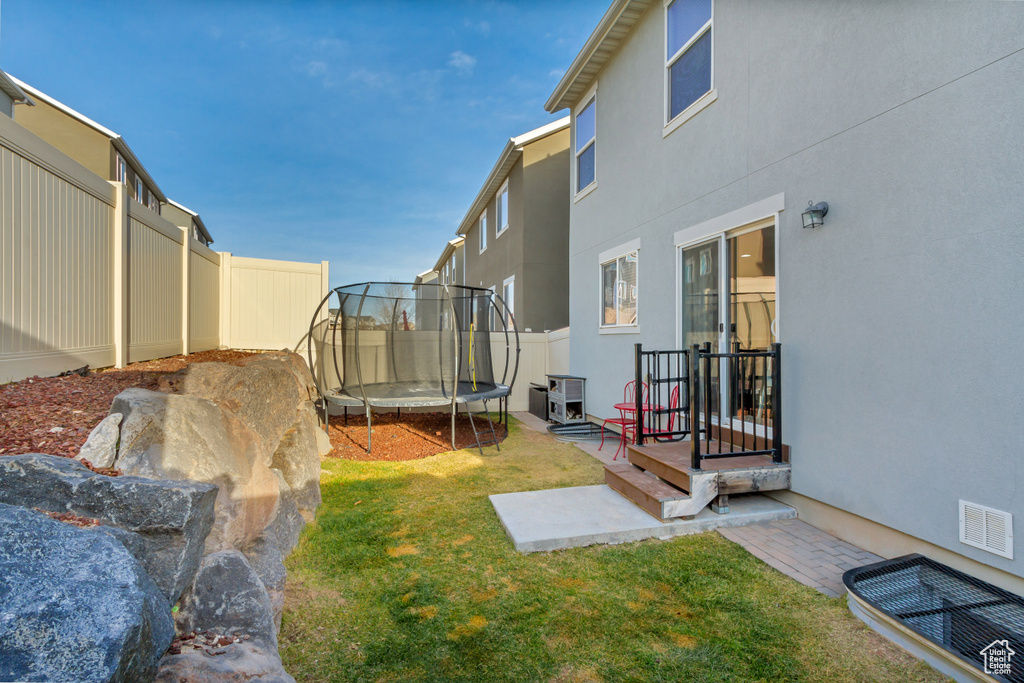 View of yard with a patio area and a trampoline