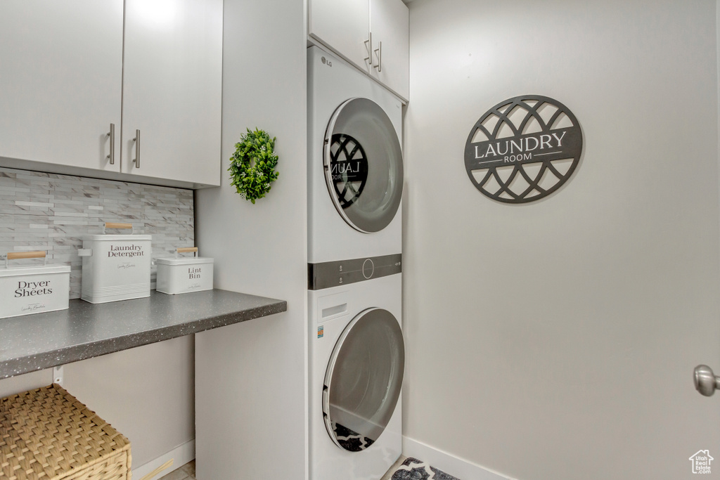 Laundry area with cabinets and stacked washer / dryer