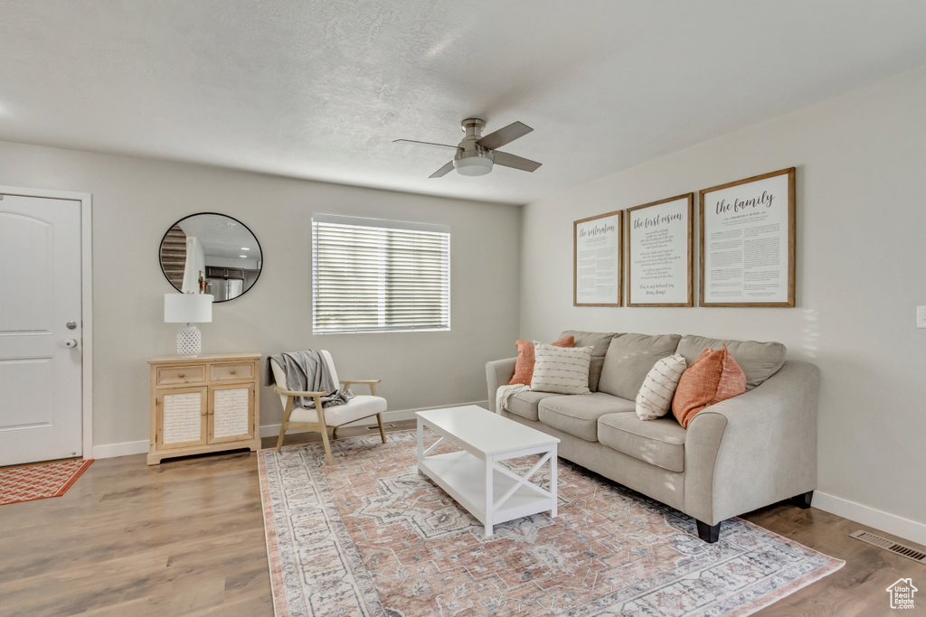 Living room with ceiling fan and wood-type flooring