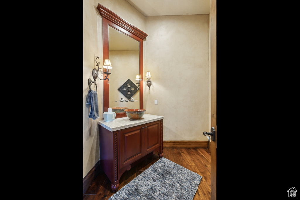 Bathroom featuring vanity, baseboards, and wood finished floors