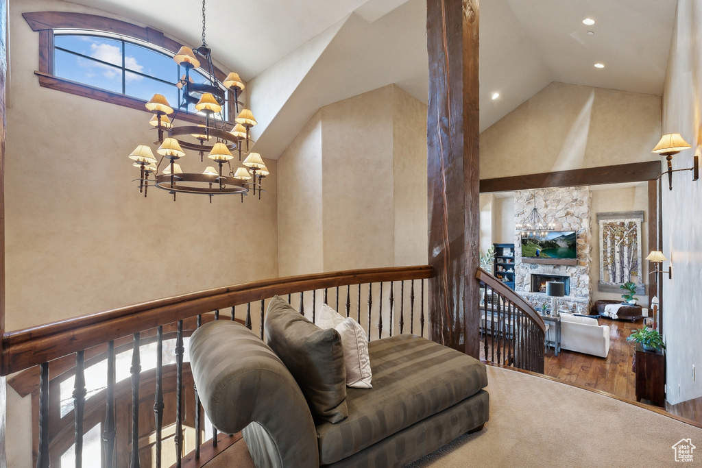 Living room featuring a chandelier, a fireplace, recessed lighting, and high vaulted ceiling
