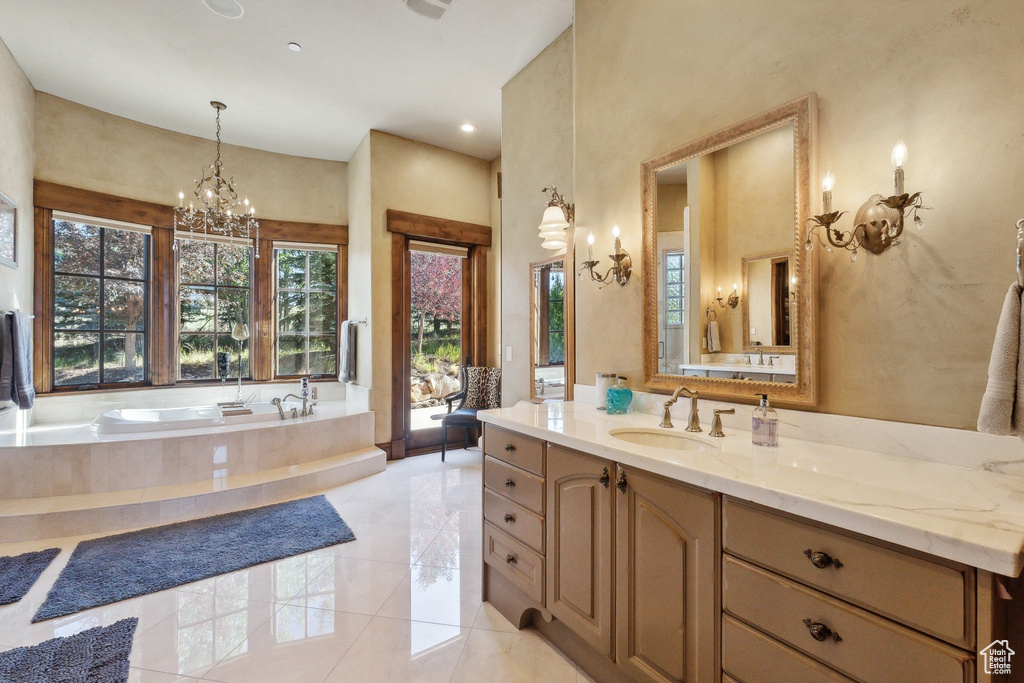 Bathroom featuring vanity, a garden tub, a chandelier, tile patterned flooring, and recessed lighting