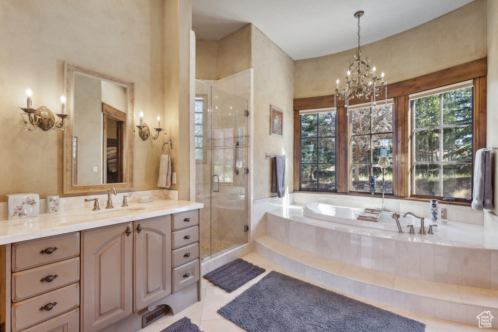 Full bathroom featuring vanity, a garden tub, a stall shower, tile patterned floors, and a chandelier