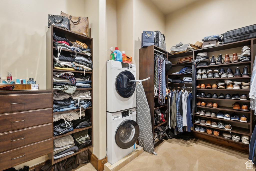 Laundry room with stacked washer / drying machine and carpet
