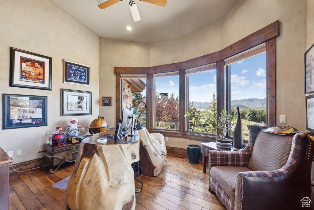 Living area featuring wood-type flooring, ceiling fan, and baseboards