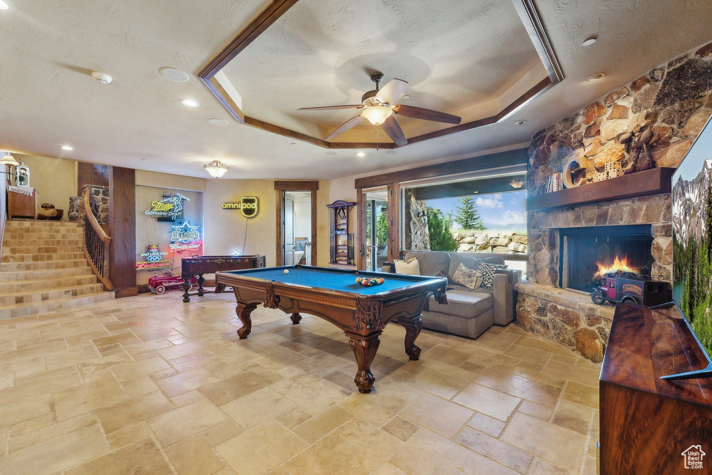 Game room with a raised ceiling, stone tile flooring, billiards, ceiling fan, and recessed lighting