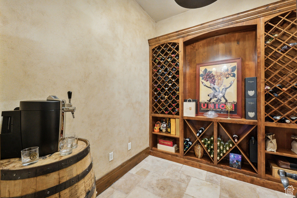 Wine cellar featuring baseboards, stone tile flooring, and a textured wall