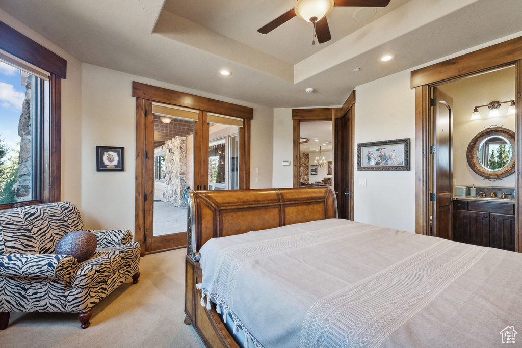 Bedroom with recessed lighting, access to outside, light carpet, a tray ceiling, and a ceiling fan