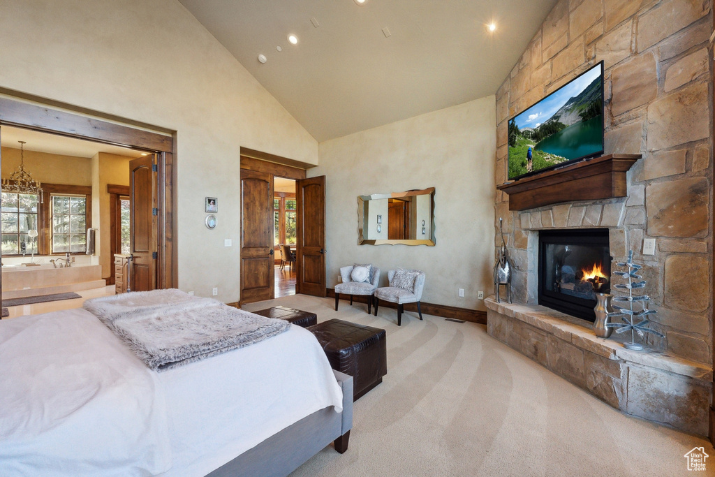 Carpeted bedroom featuring high vaulted ceiling, a fireplace, recessed lighting, connected bathroom, and baseboards